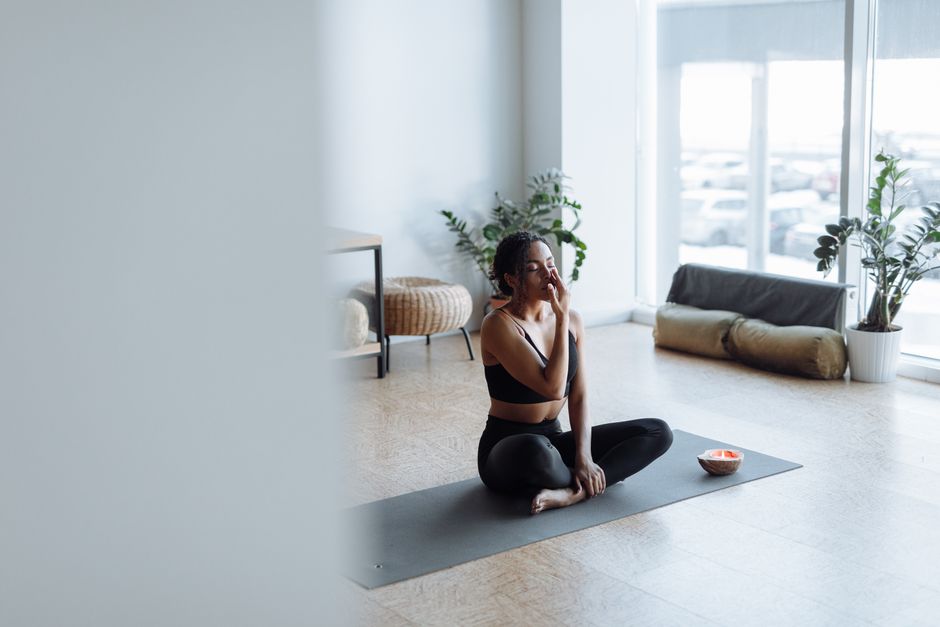 Woman meditating beside an open window
