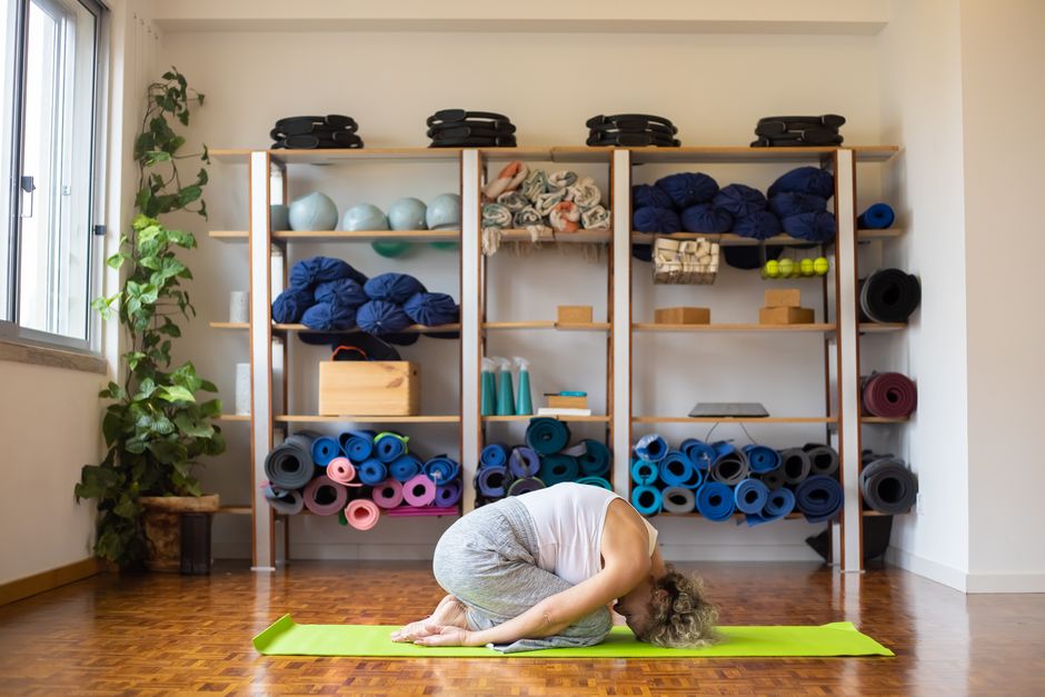 Student resting over a bolster in a restorative pose